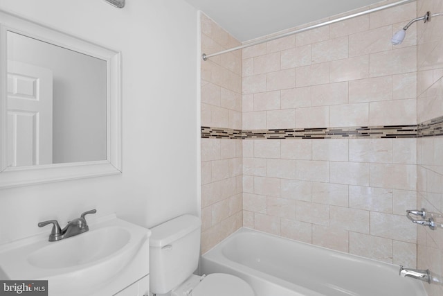 full bathroom with tiled shower / bath, vanity, and toilet