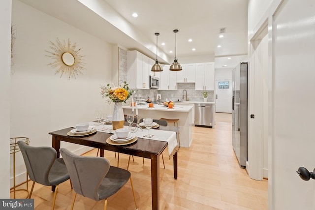 dining area with light hardwood / wood-style flooring and sink