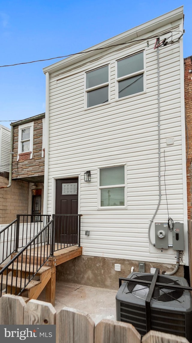 rear view of property with cooling unit