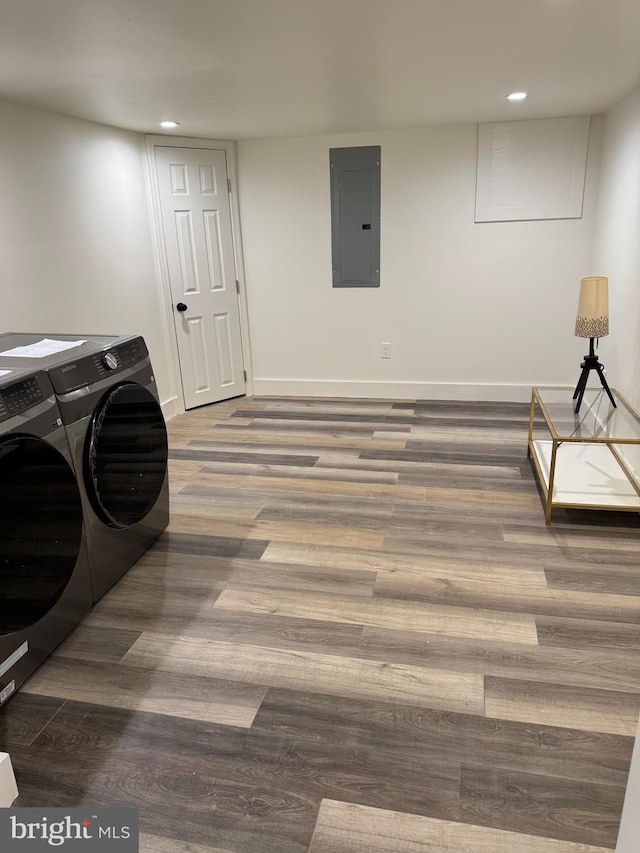 laundry room with washing machine and dryer, dark wood-type flooring, and electric panel