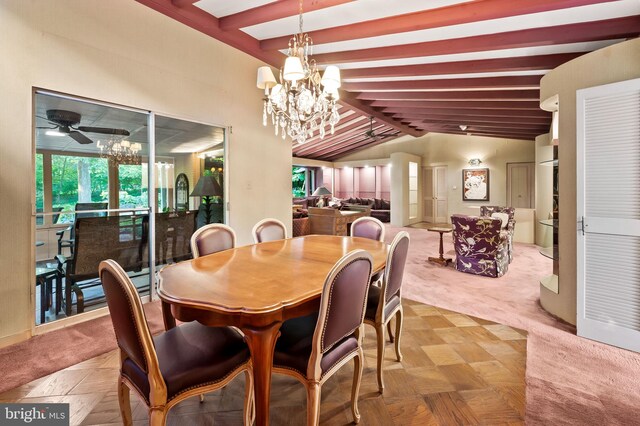 dining area featuring ceiling fan with notable chandelier and vaulted ceiling with beams