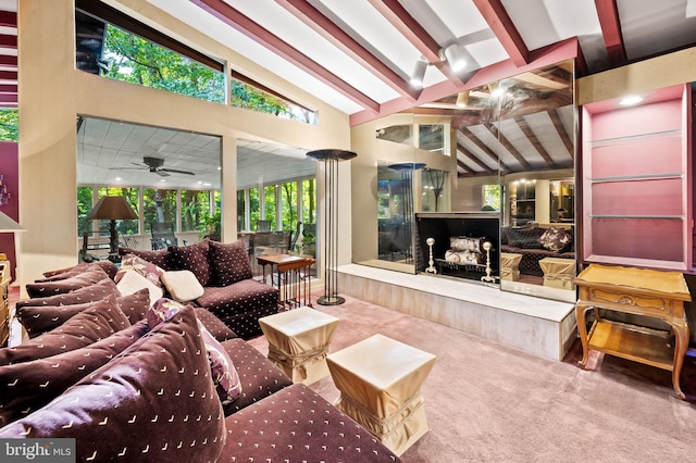 living room with beamed ceiling, a premium fireplace, high vaulted ceiling, carpet, and ceiling fan