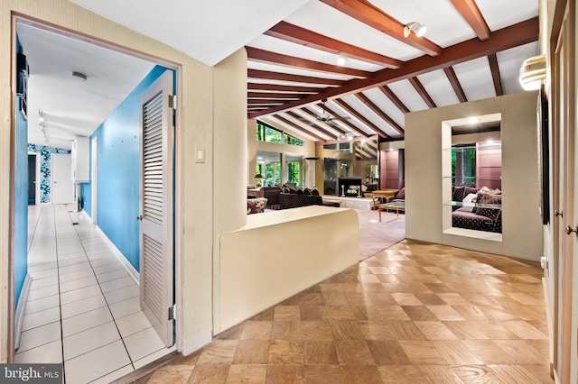 hallway featuring lofted ceiling with beams and light tile patterned floors