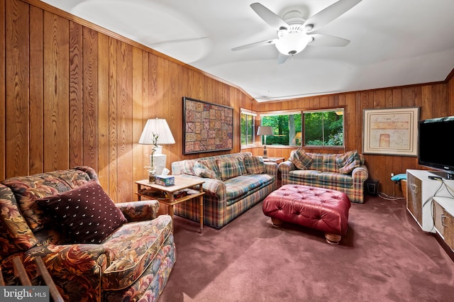 living room featuring lofted ceiling, ceiling fan, wood walls, and carpet flooring