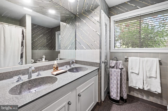 bathroom featuring vanity and tile walls