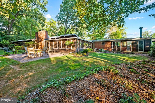 view of yard with a sunroom and a patio area