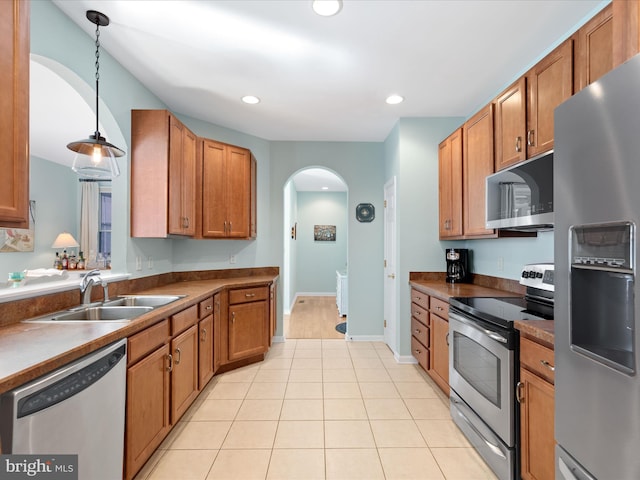 kitchen with stainless steel appliances, hanging light fixtures, light tile patterned flooring, and sink