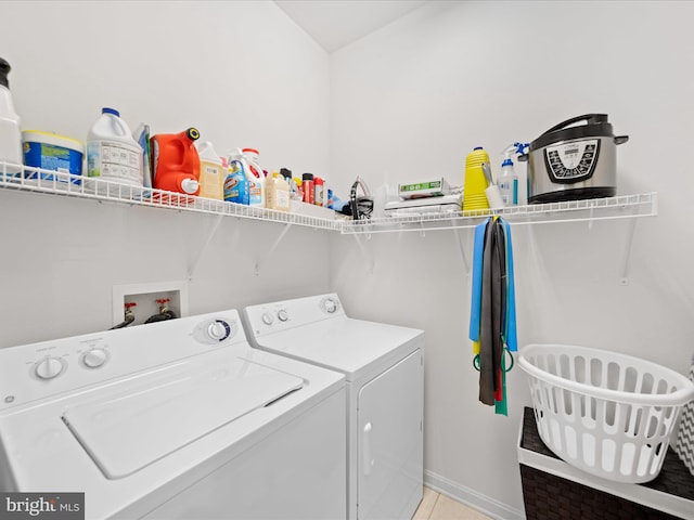 laundry room with washer and clothes dryer and light tile patterned floors