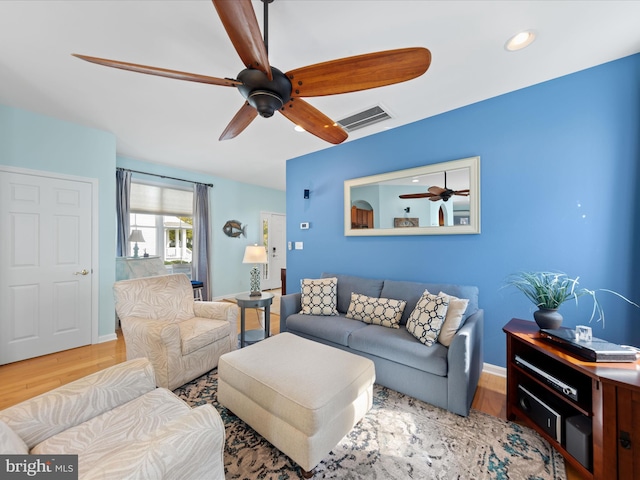 living room with wood-type flooring and ceiling fan