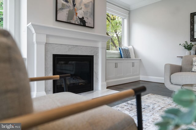 living room with crown molding, dark hardwood / wood-style floors, and a high end fireplace