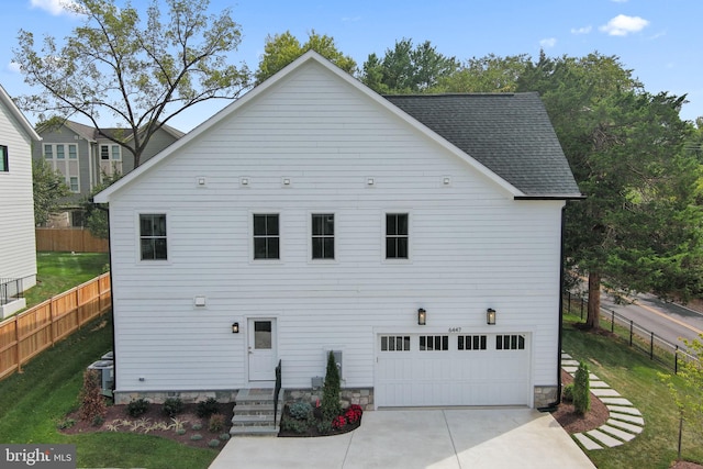 view of front of home with a garage, central air condition unit, and a front lawn