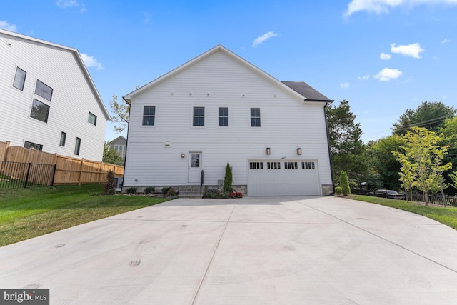 rear view of property with a yard and a garage