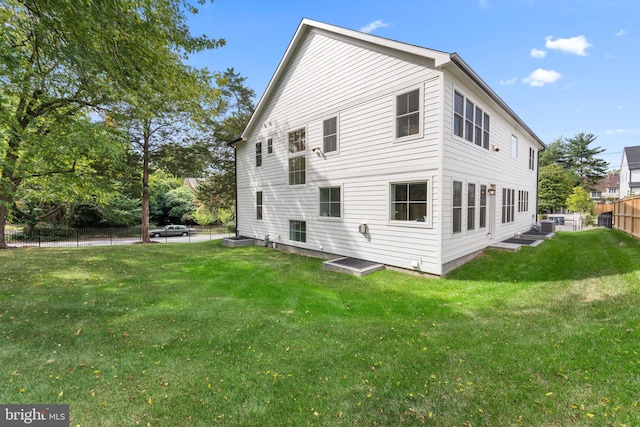 view of side of home with a lawn and cooling unit