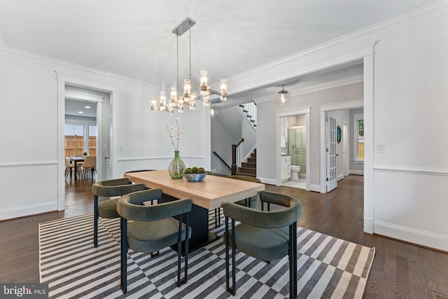 dining space with ornamental molding, dark wood-type flooring, and a chandelier