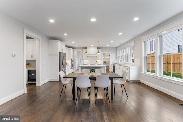 dining space featuring wine cooler, dark wood-type flooring, and sink