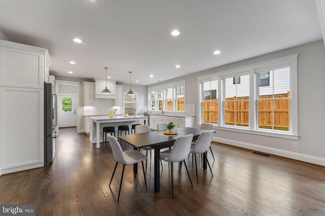 dining area with sink, dark wood-type flooring, and a wealth of natural light