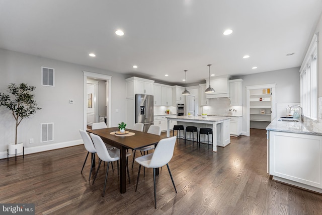 dining space with dark wood-type flooring and sink