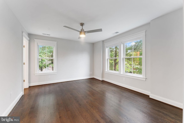 spare room with ceiling fan, dark wood-type flooring, and a wealth of natural light