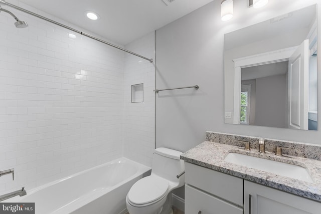 full bathroom featuring tiled shower / bath, vanity, and toilet