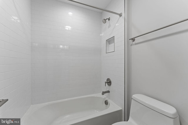 bathroom with tiled shower / bath and toilet