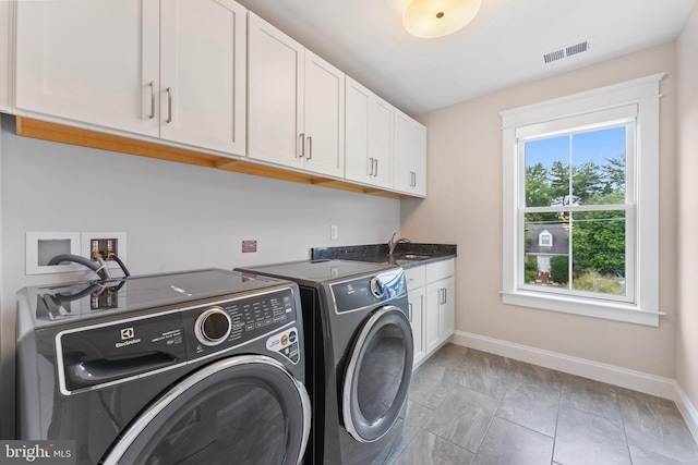 laundry room featuring sink, independent washer and dryer, and cabinets