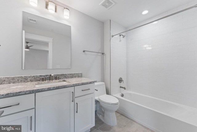 full bathroom with tiled shower / bath, vanity, ceiling fan, toilet, and tile patterned floors