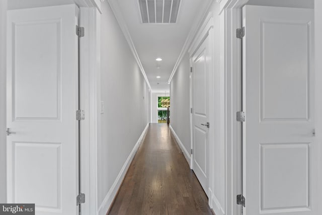 hallway with ornamental molding and dark hardwood / wood-style flooring