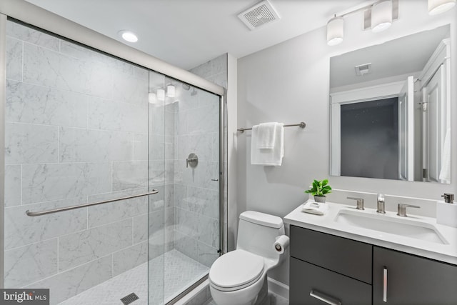 bathroom with vanity, toilet, and a shower with door