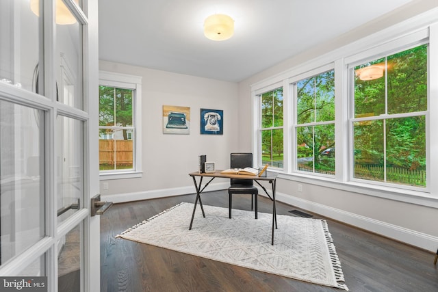 home office featuring dark hardwood / wood-style flooring and a healthy amount of sunlight