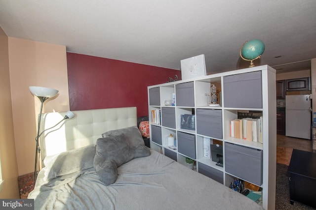 bedroom featuring white refrigerator