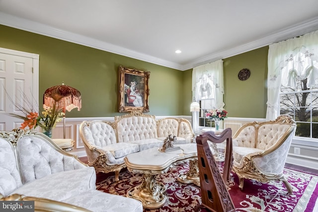 living area with wood-type flooring, a wealth of natural light, and crown molding