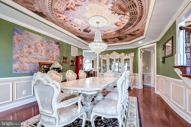 dining space with dark hardwood / wood-style flooring, an inviting chandelier, a raised ceiling, and crown molding