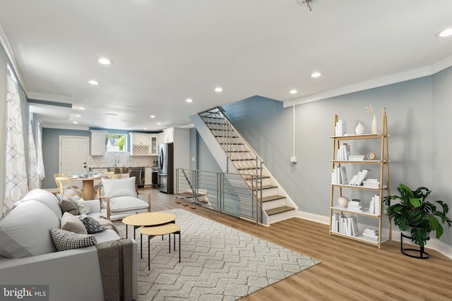 living room featuring crown molding and light hardwood / wood-style flooring