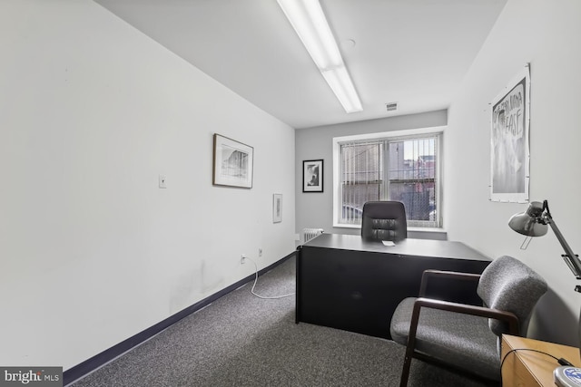 carpeted home office with radiator heating unit