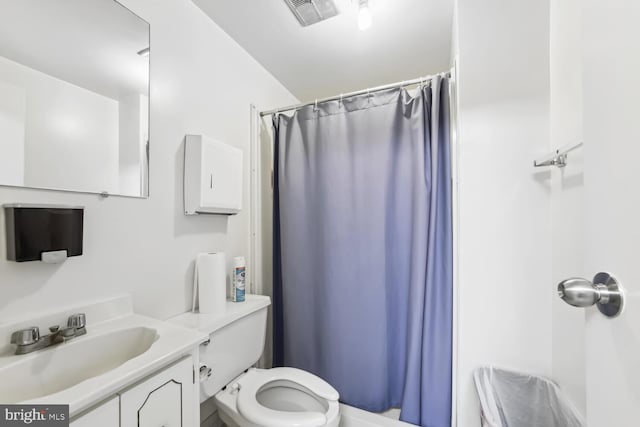 bathroom with curtained shower, vanity, and toilet