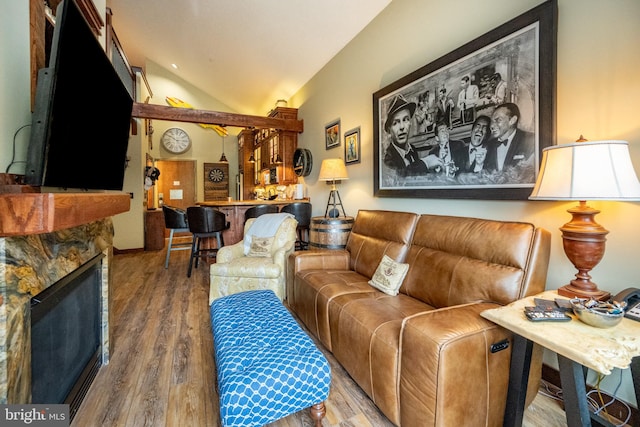 living room featuring lofted ceiling, a fireplace, and hardwood / wood-style flooring