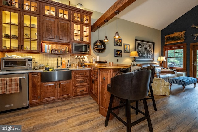 bar with sink, stainless steel appliances, high vaulted ceiling, decorative backsplash, and dark hardwood / wood-style floors