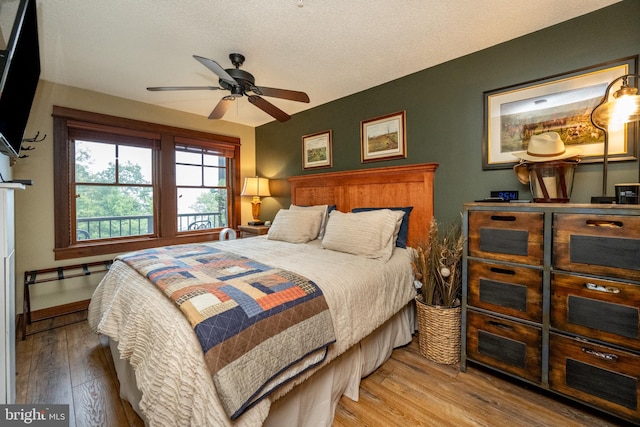 bedroom featuring ceiling fan, a textured ceiling, and light wood-type flooring