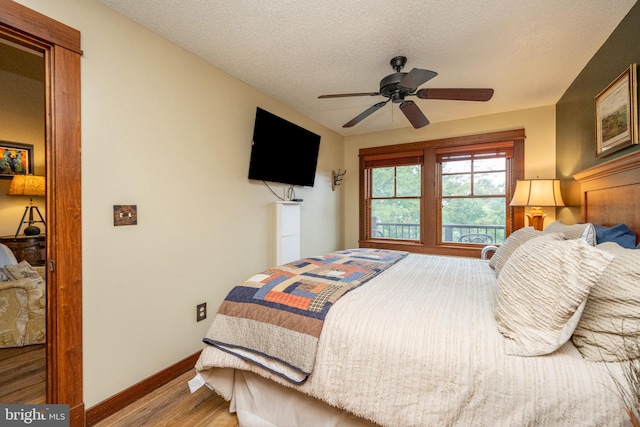 bedroom featuring a textured ceiling, wood-type flooring, and ceiling fan