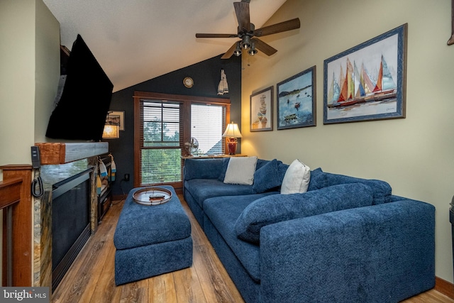 living room with hardwood / wood-style floors, ceiling fan, and vaulted ceiling