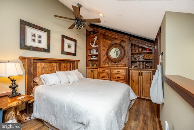 bedroom with ceiling fan, dark wood-type flooring, and vaulted ceiling