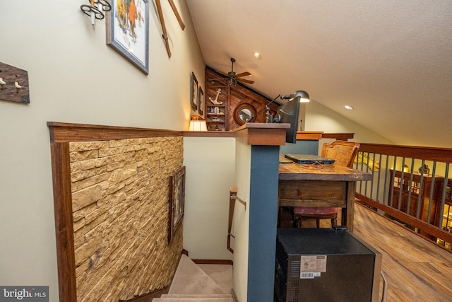 interior space with lofted ceiling, a textured ceiling, and ceiling fan