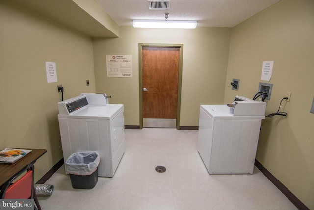 washroom featuring a textured ceiling and separate washer and dryer