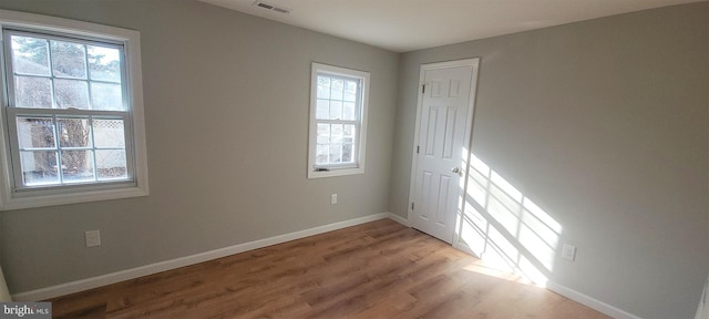 spare room with plenty of natural light and light hardwood / wood-style floors