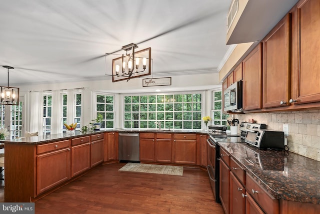 kitchen with pendant lighting, kitchen peninsula, stainless steel appliances, a notable chandelier, and dark hardwood / wood-style flooring