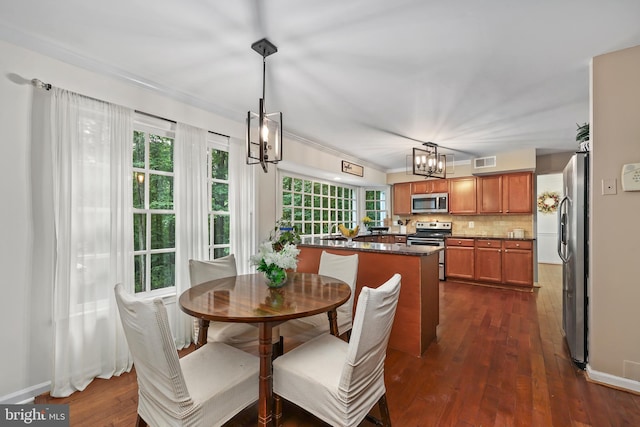 dining room with ornamental molding, dark hardwood / wood-style floors, and a chandelier