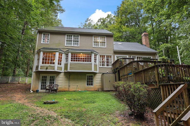 back of property with a lawn and a wooden deck