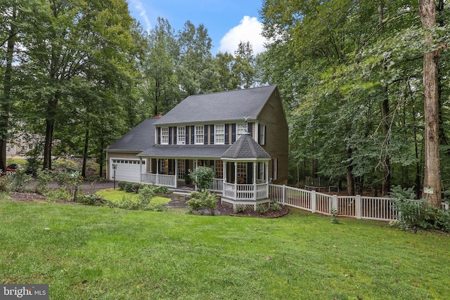 view of front of house with covered porch, a front yard, and a garage