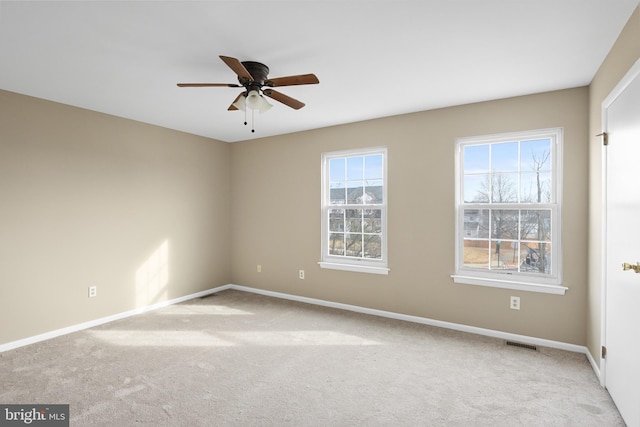 spare room featuring light colored carpet and ceiling fan