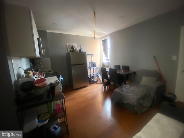 interior space with light hardwood / wood-style floors, sink, and stainless steel fridge